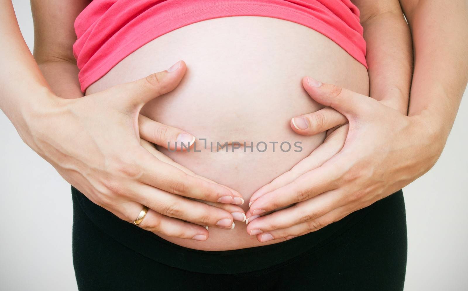 Husband hands on pregnant woman belly