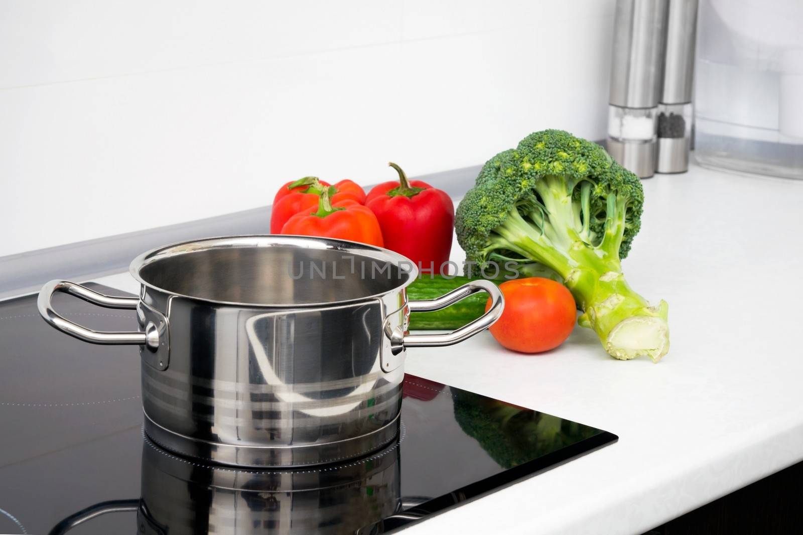 Pot and vegetables in modern kitchen with induction stove by simpson33