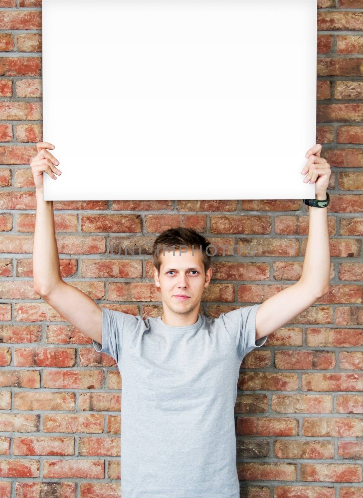 Young man holding blank whiteboard on business presentation by simpson33