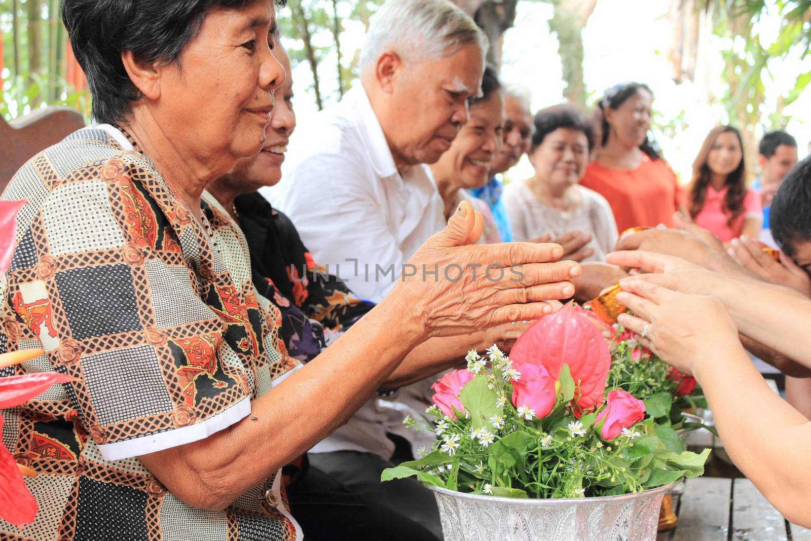 KRABI, THAILAND - APRIL 16: Unidentified Thai people celebrate Songkran (new year / water festival) by giving garlands to their seniors and asked for blessings on April 16, 2013 in Krabi, Thailand.