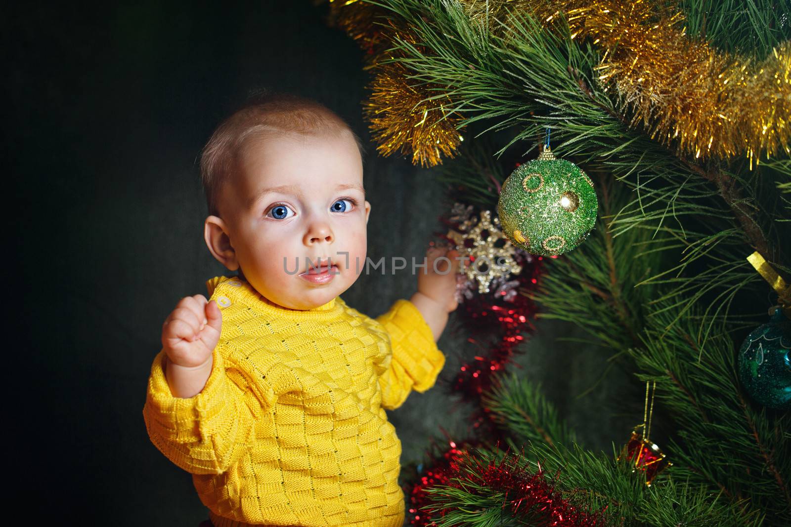 Blue-eyed little girl dresses up Christmas tree