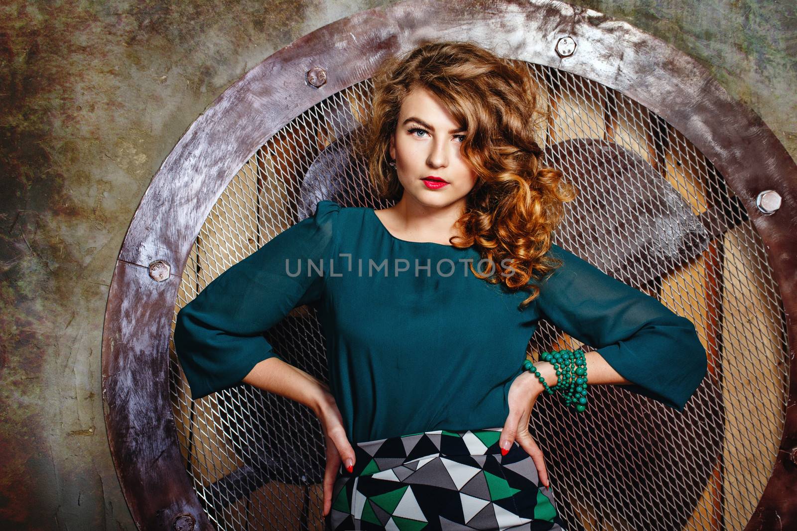 Attractive young girl model with curly hair on background of large fan