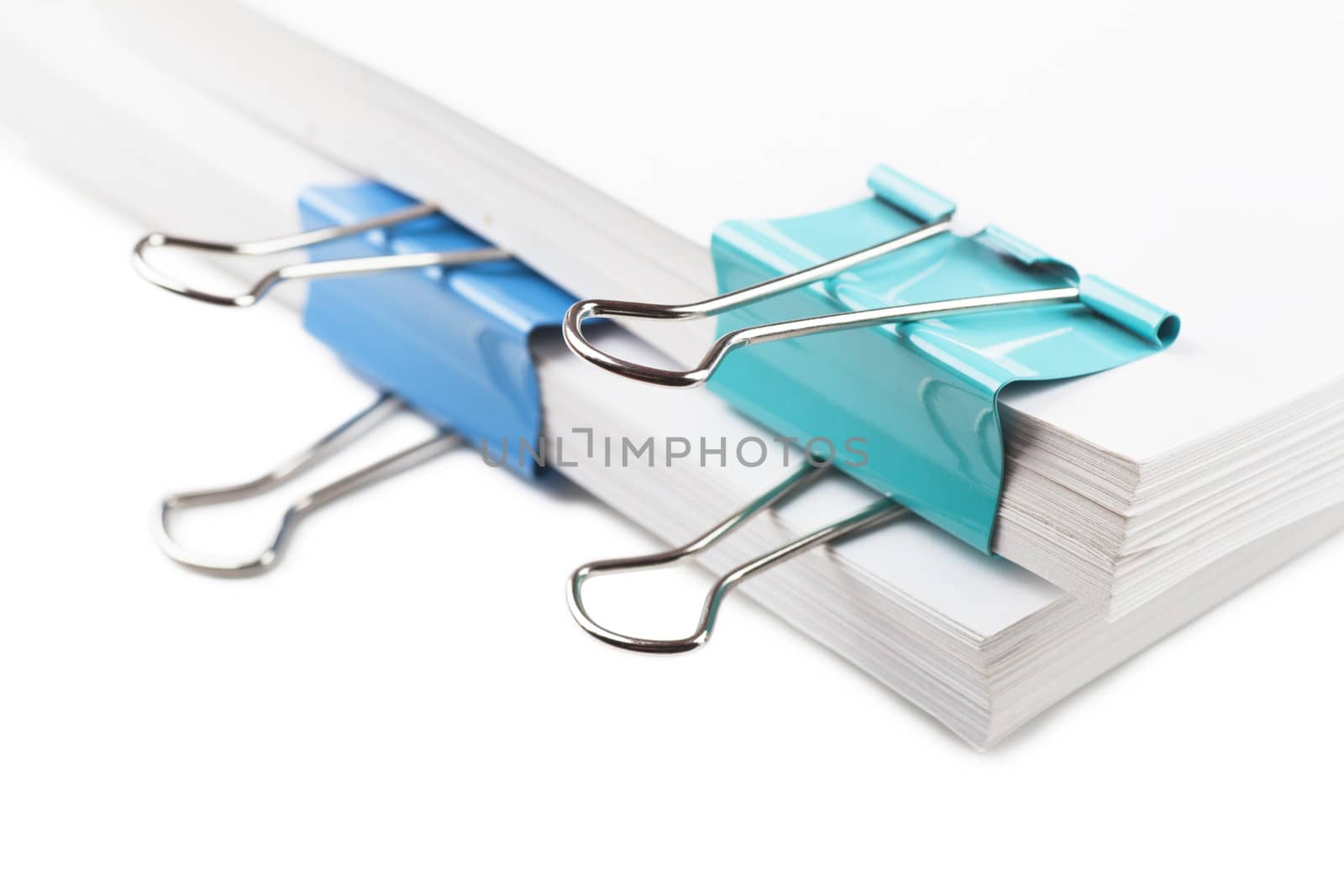 Closeup view of blue metal clips on white paper