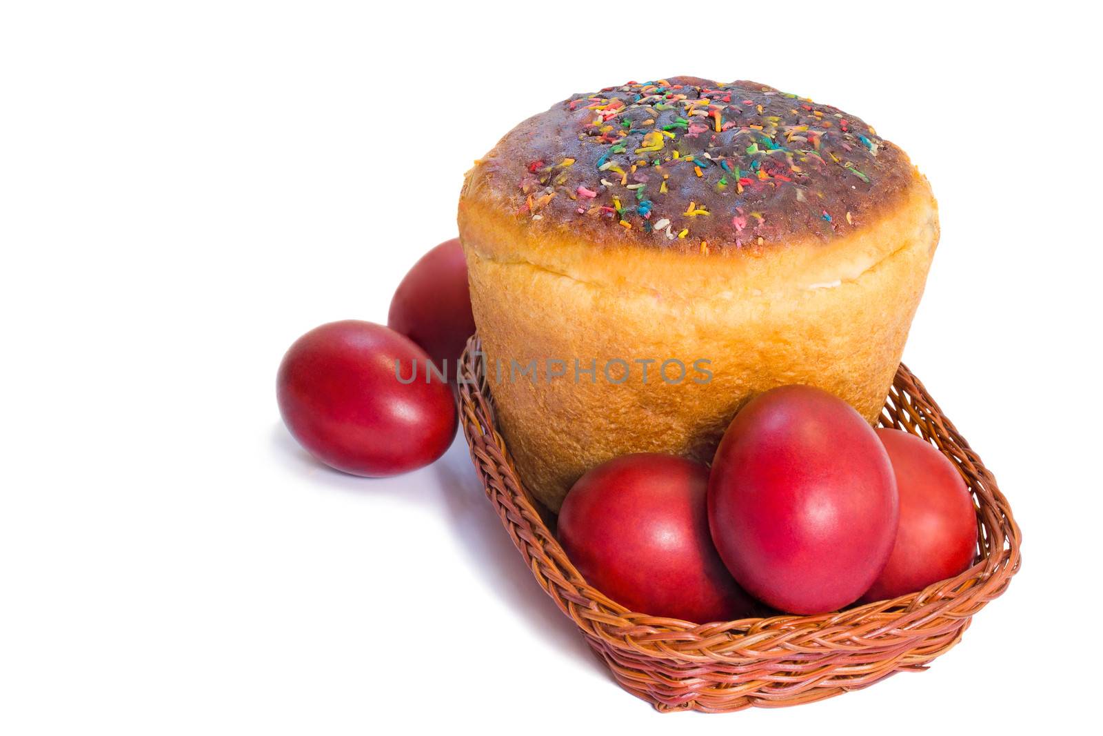 Red Easter eggs and Easter bread in a basket on a white backgrou by georgina198