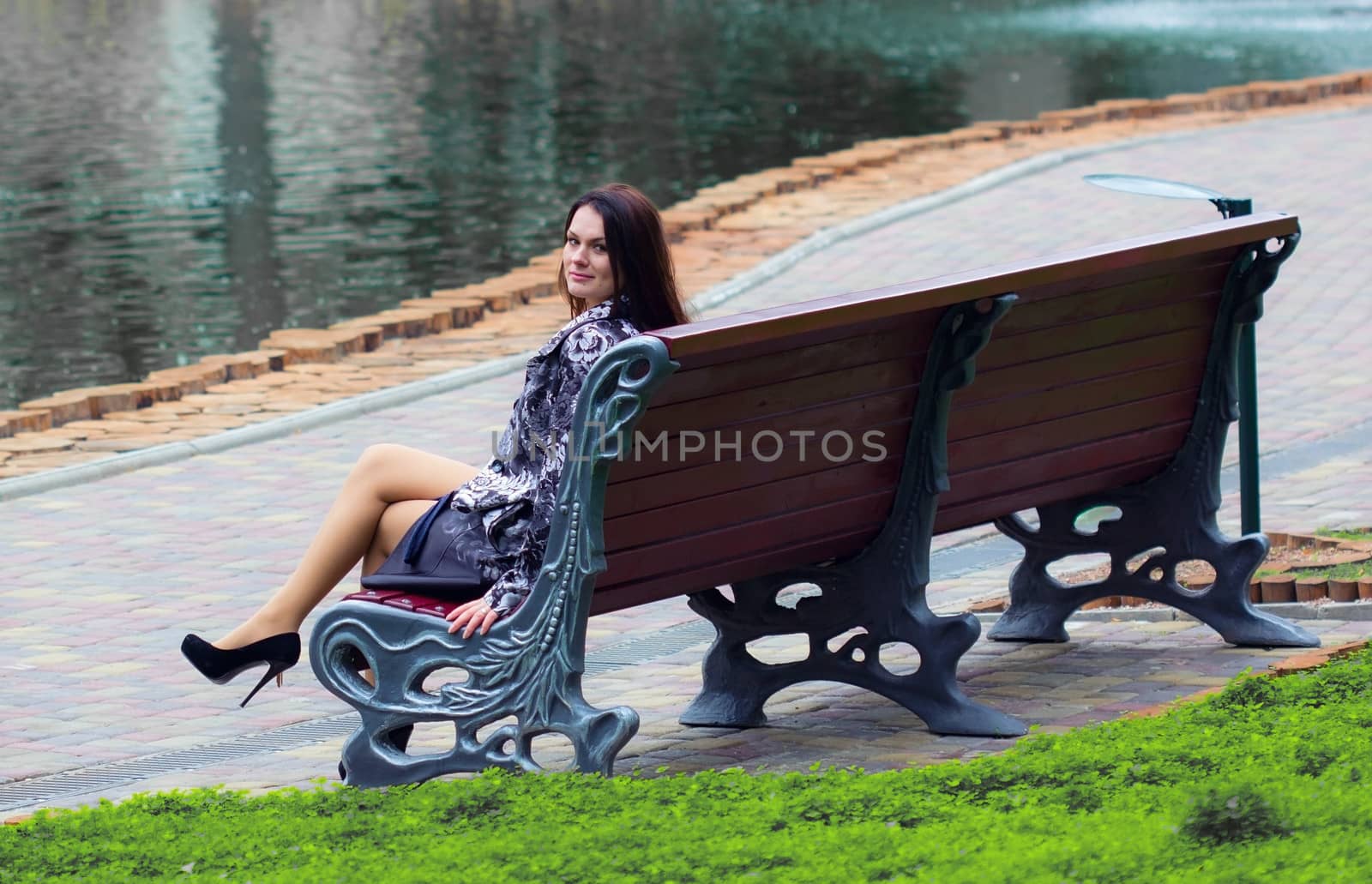 Woman sitting near the river at the bench