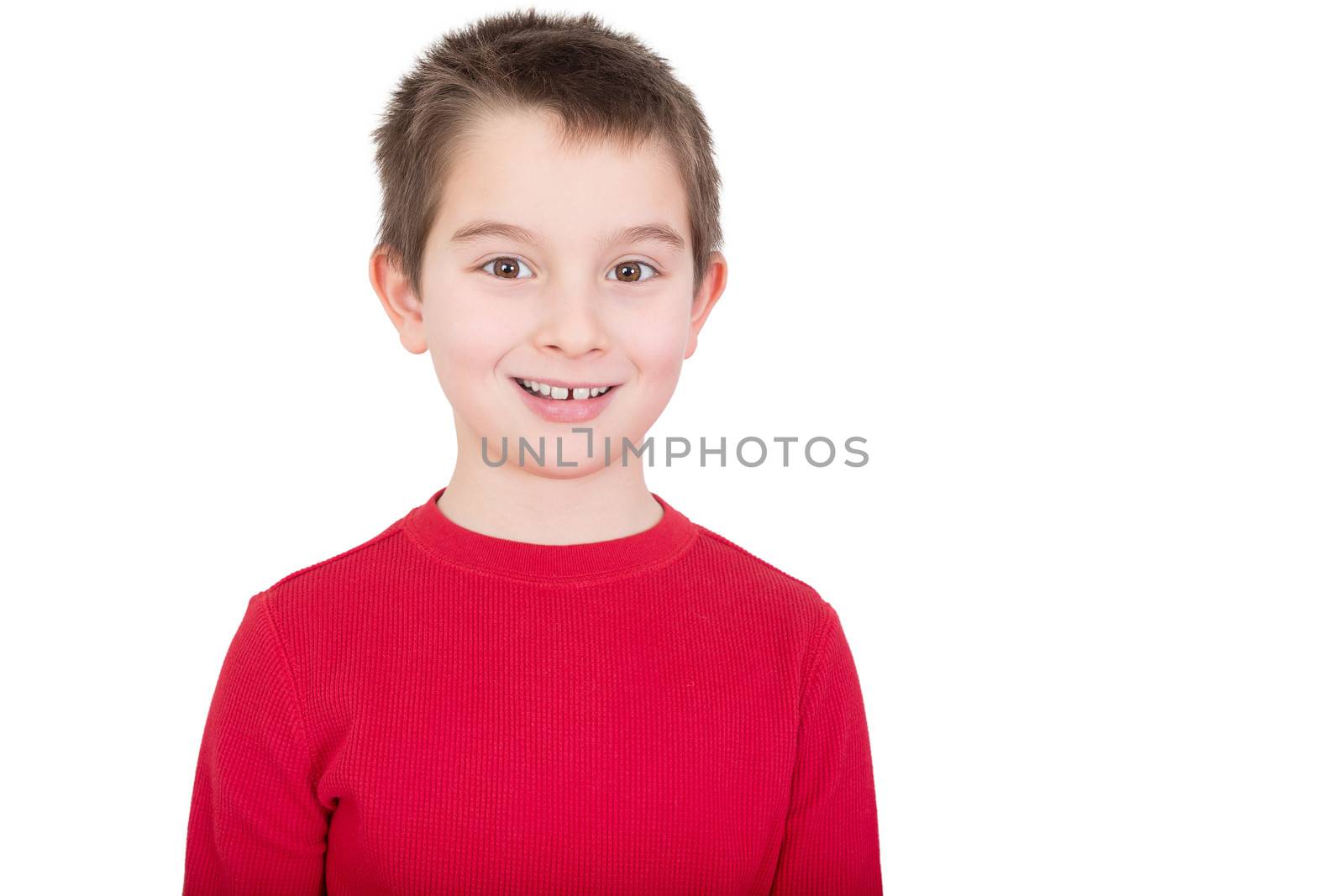 Young boy in a red t-shirt with a happy grin and alert expression, isolated on white