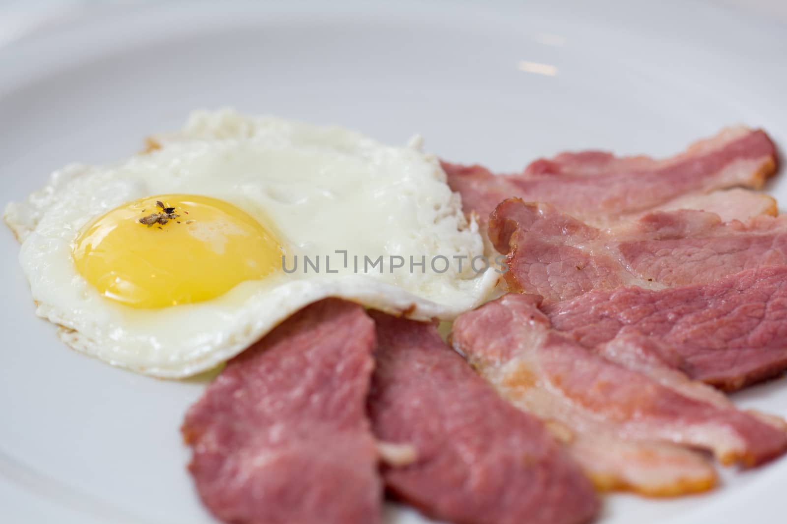 Fried egg with bacon at the plate