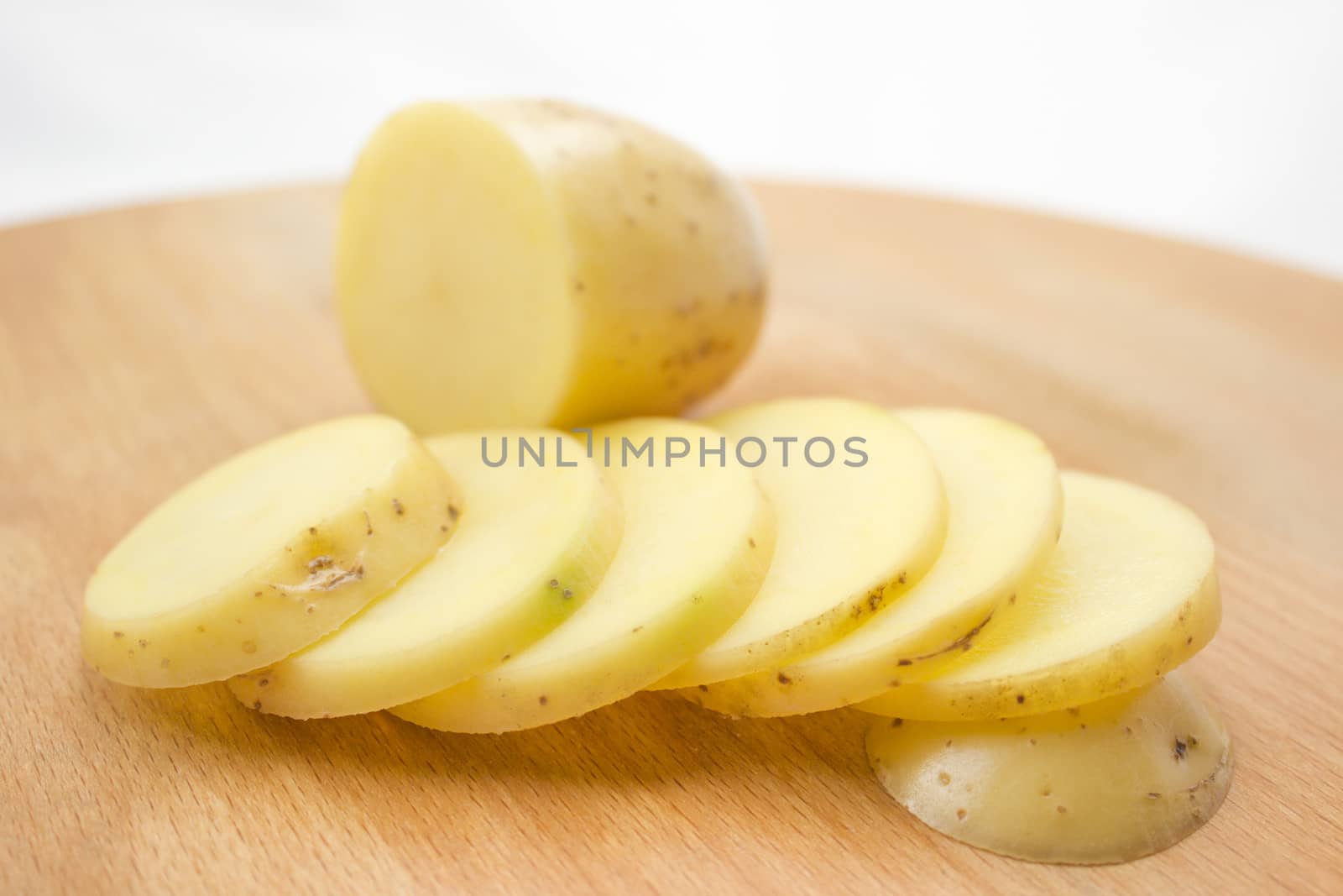 Sliced potato on a wooden cutting board.