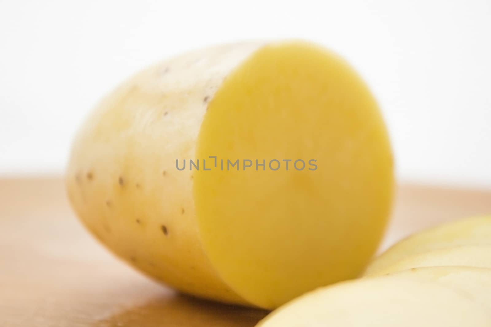 Sliced potato on a wooden cutting board.