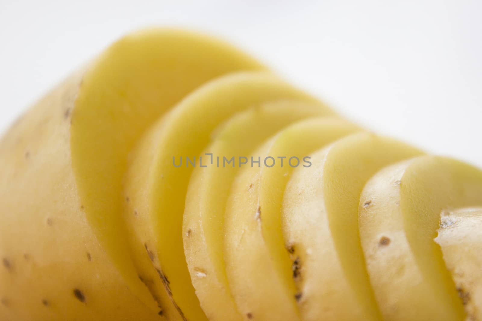 Sliced potato on a wooden cutting board.