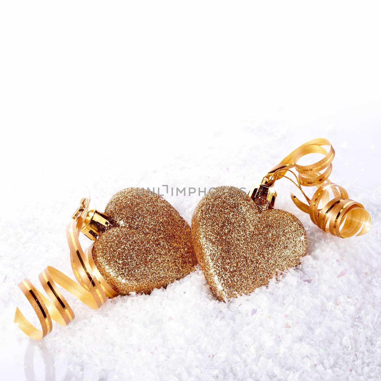 Two hearts with gold tapes on snow by Azaliya