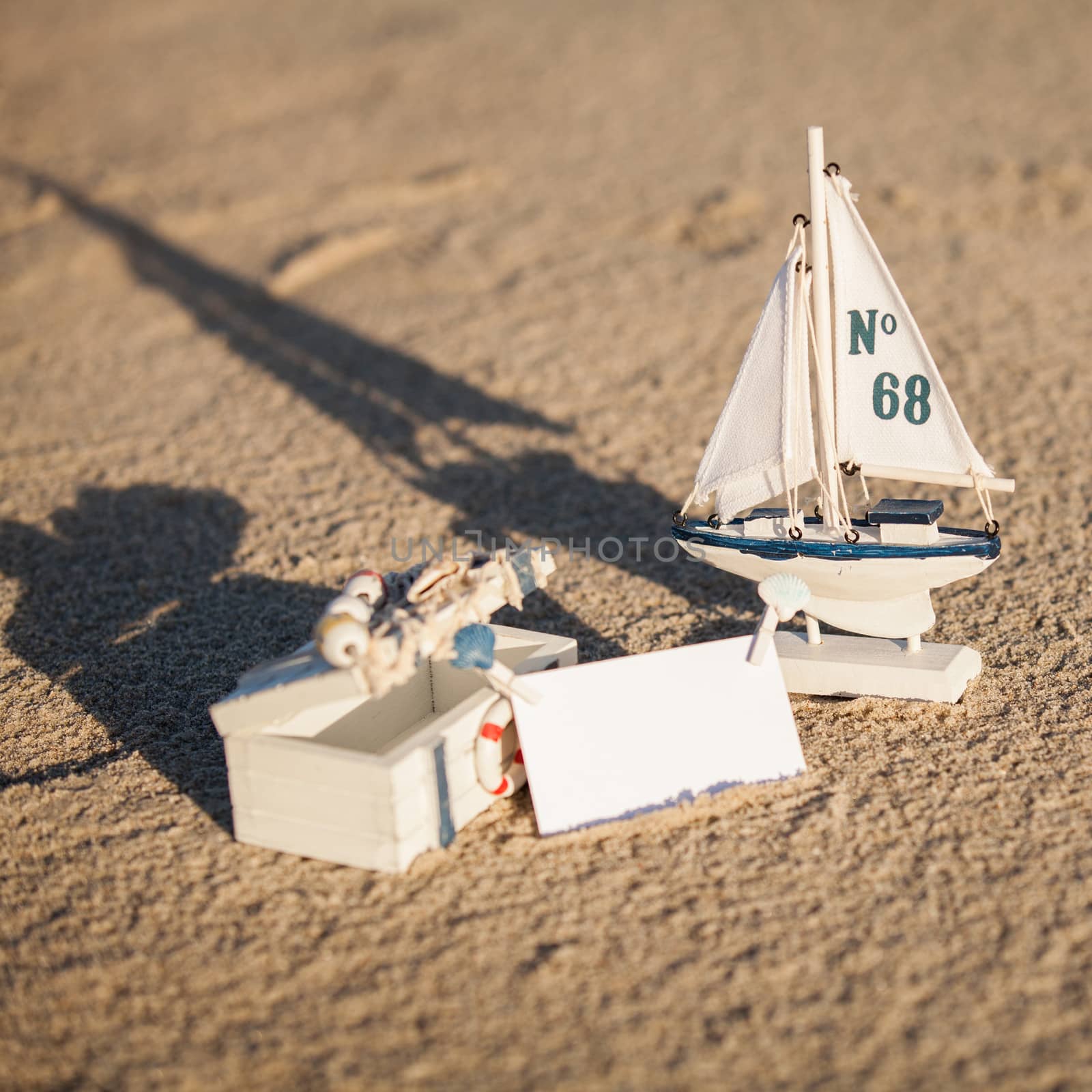 sailing boat and seashell in sand decoration closeup by juniart