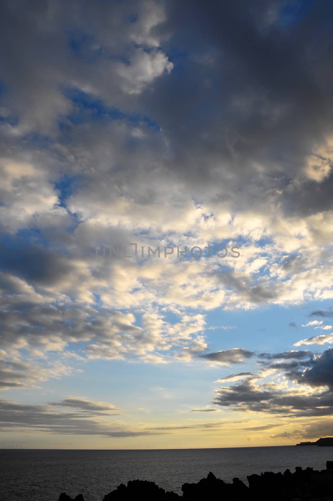 Some Colored Clouds over the Ocean on a Blue Sky