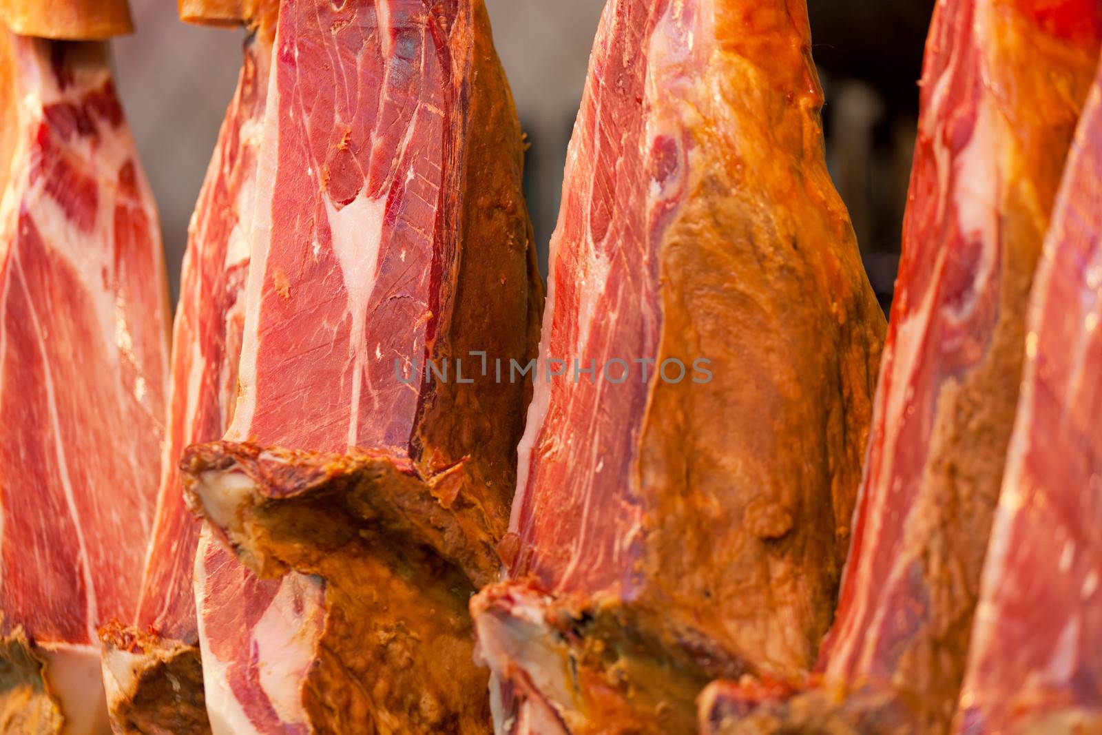 Famous spanish hamon close up hanging above counter by elena_shchipkova