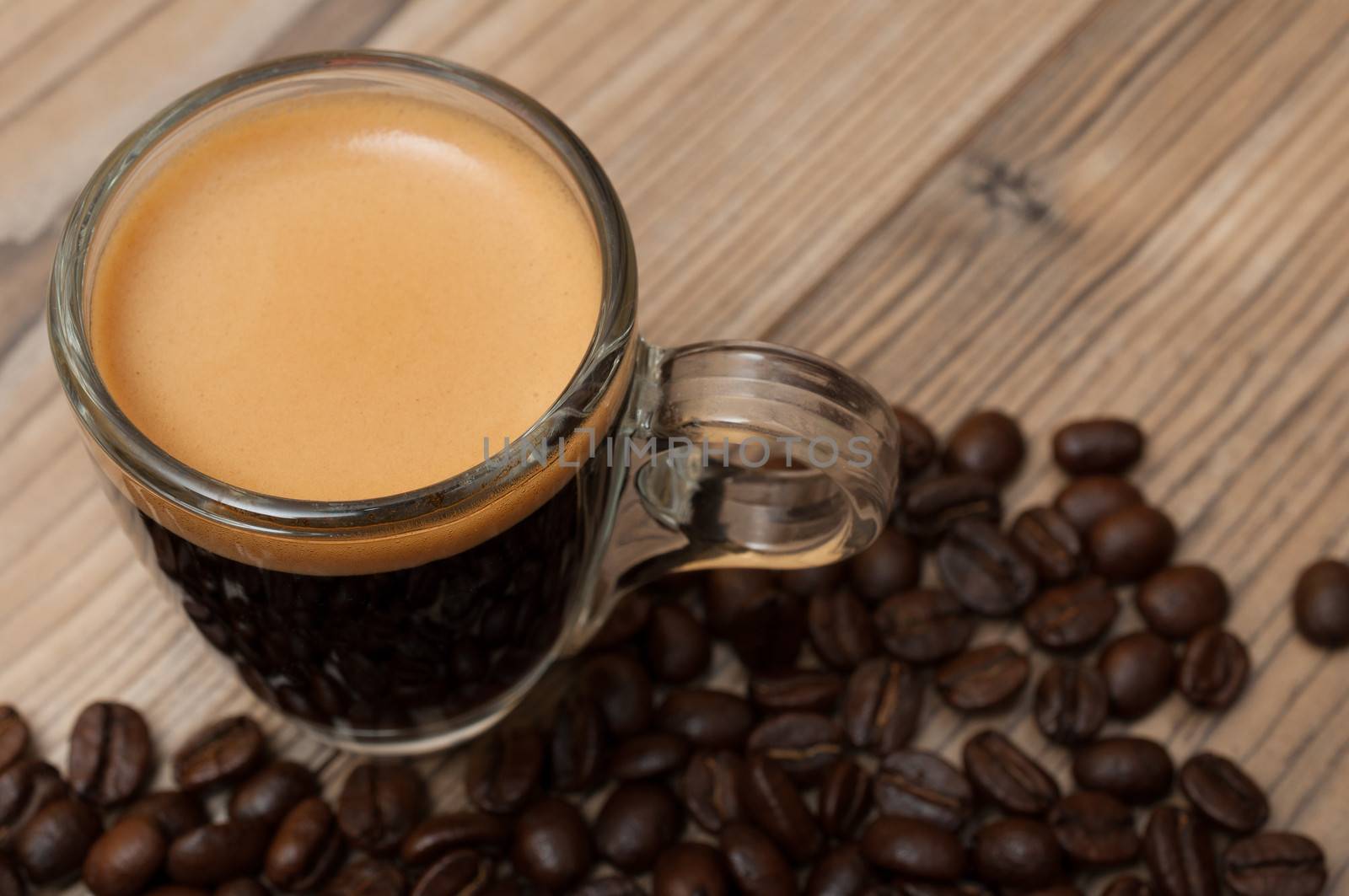 Glass Cup of Espresso Coffee on Wooden Table With Coffee Beans - Shallow Depth of Field