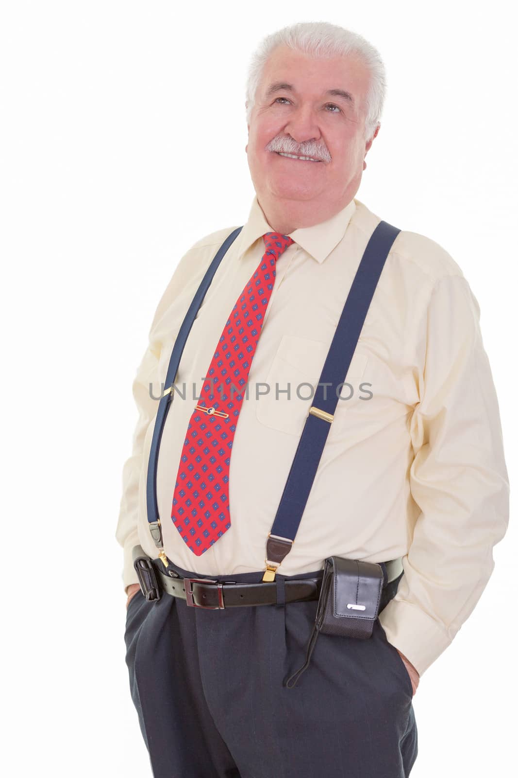 A portrait of a senior gentlemen, dressed in shirt and tie with braces, smiling wistfully.