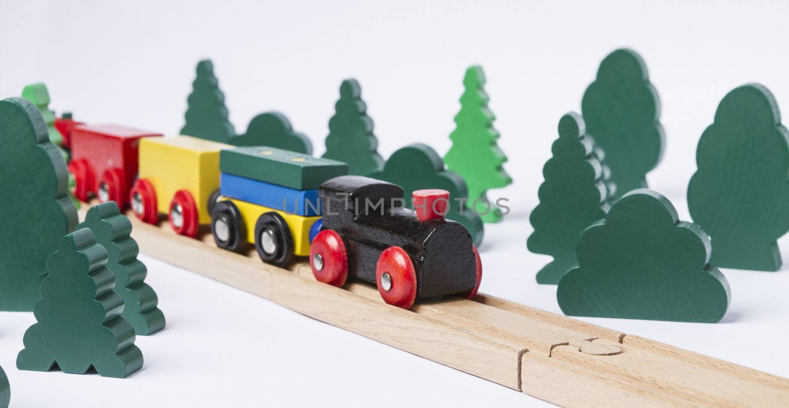 black wooden toy train in rural landscape made with simple toy trees