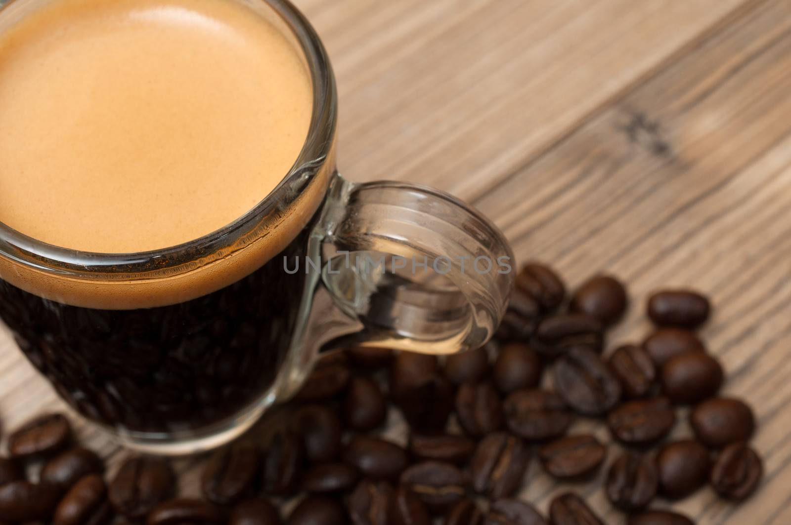 Glass Cup of Espresso Coffee on Wooden Table With Coffee Beans - Shallow Depth of Field