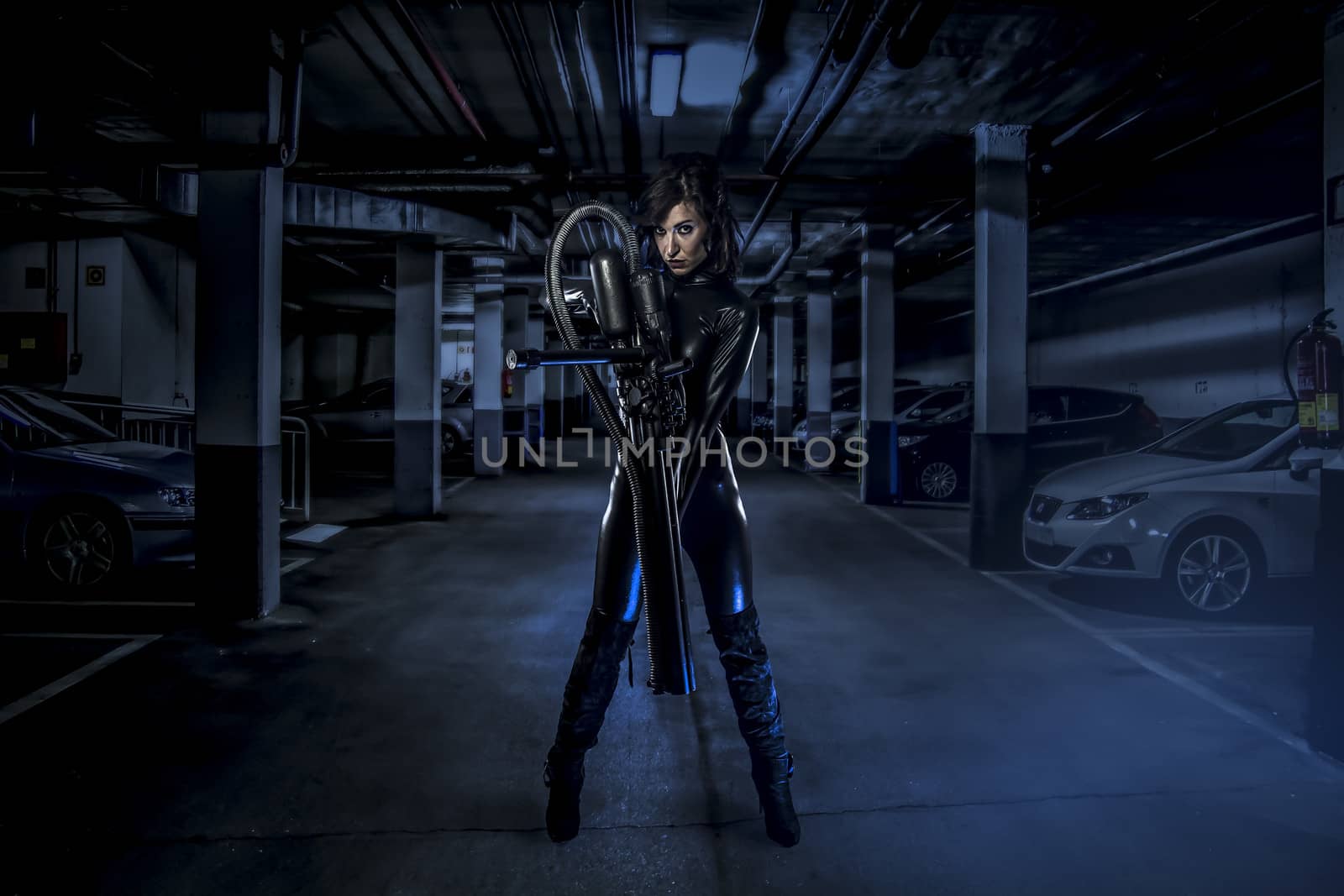armed woman in a garage, future concept, black latex with neon lights