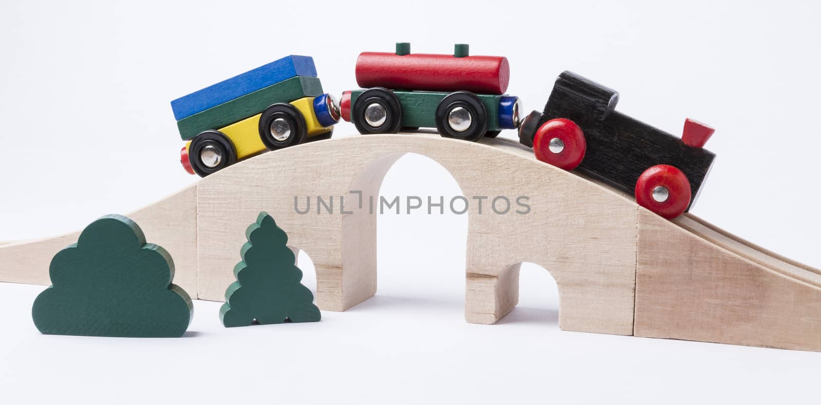 wooden toy train on bridge in grey background. horizontal image