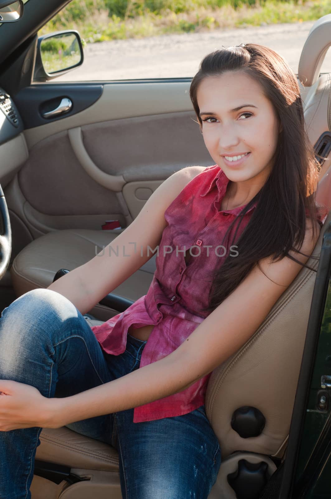 Brunette woman with long hair sitting in car