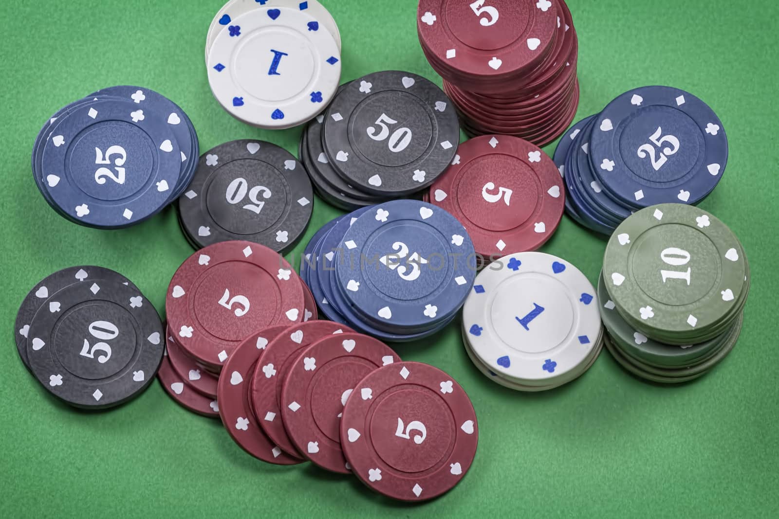 Different types of poker chips on green background