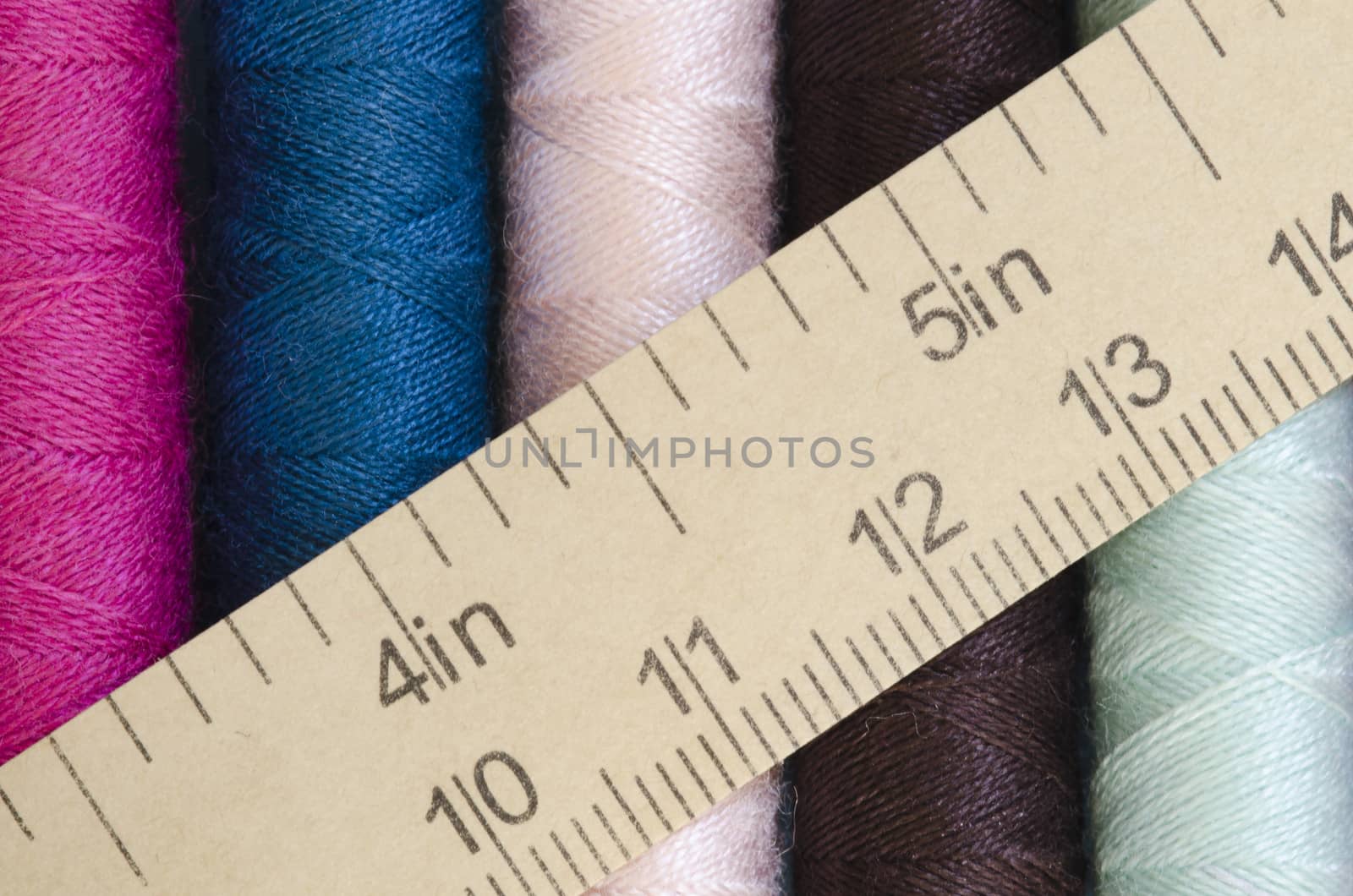 sewing thread in many colors with measuring tape texture background