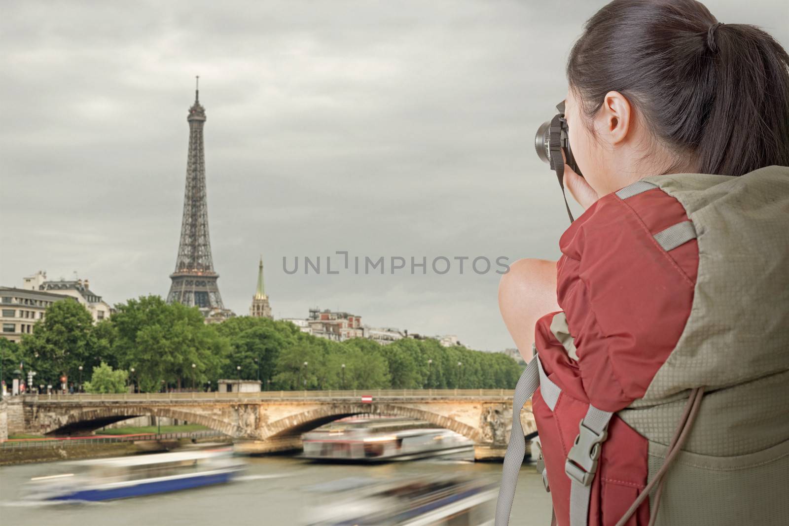 Young backpacker travel and take picture in Paris with famous Eiffel Tower.