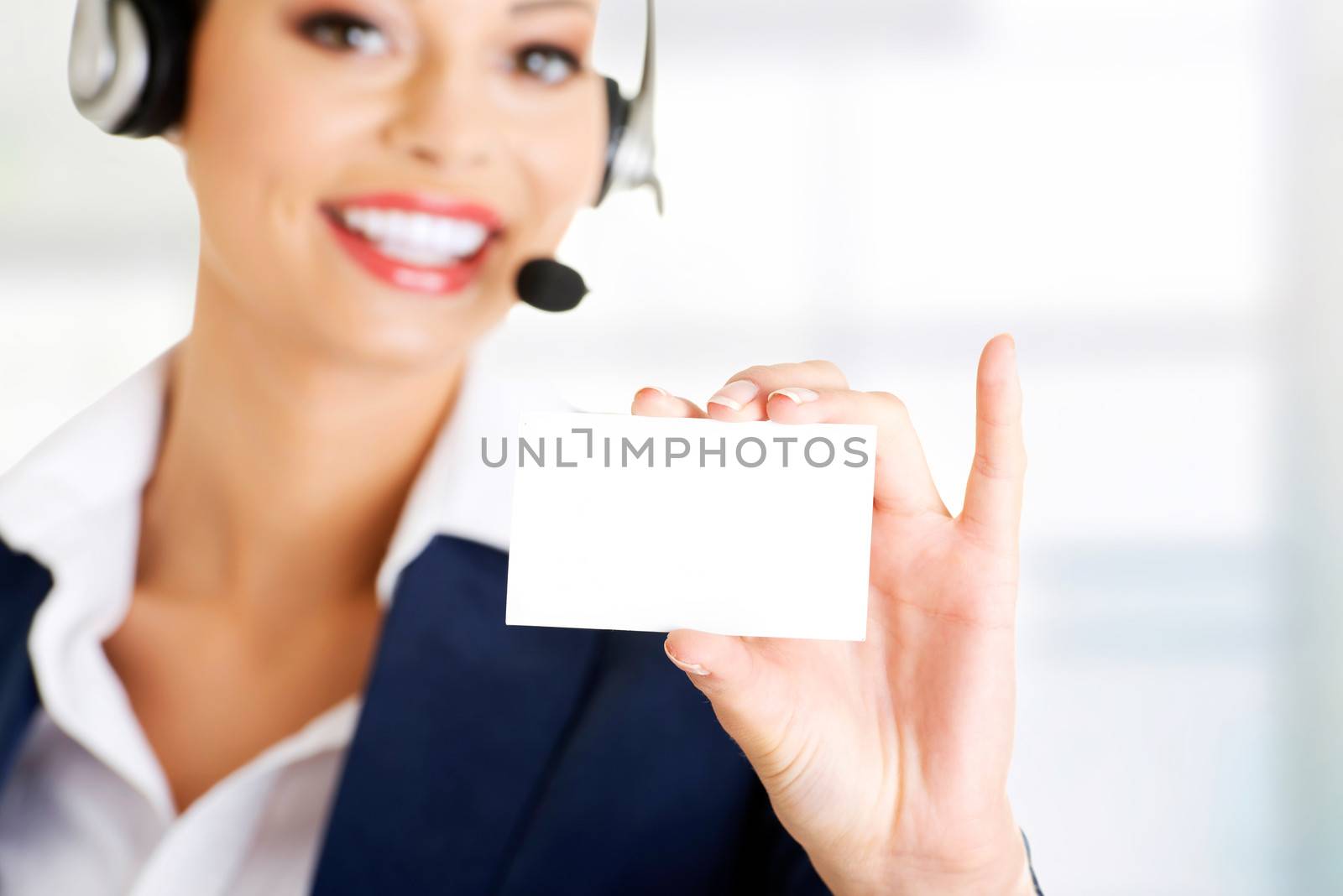 Smiling customer service representative with headset holding a blank empty card. Isolated on white background.