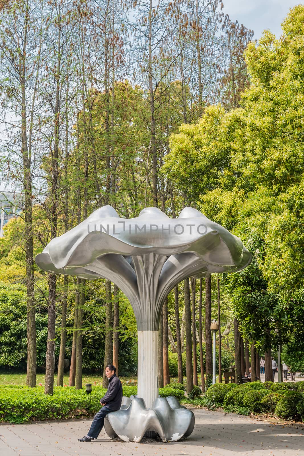 SHANGHAI - APRIL 7, 2013: one man sitting comptemporary design public bench in people's park on april 7th, 2013 in Shanghai