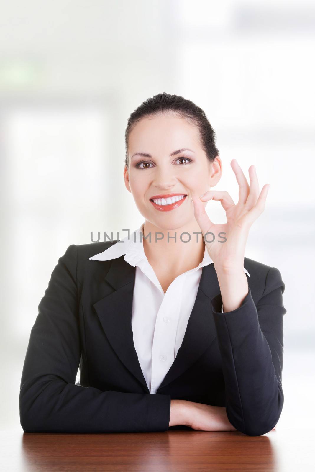 Young woman at the desk gesturing perfect by BDS