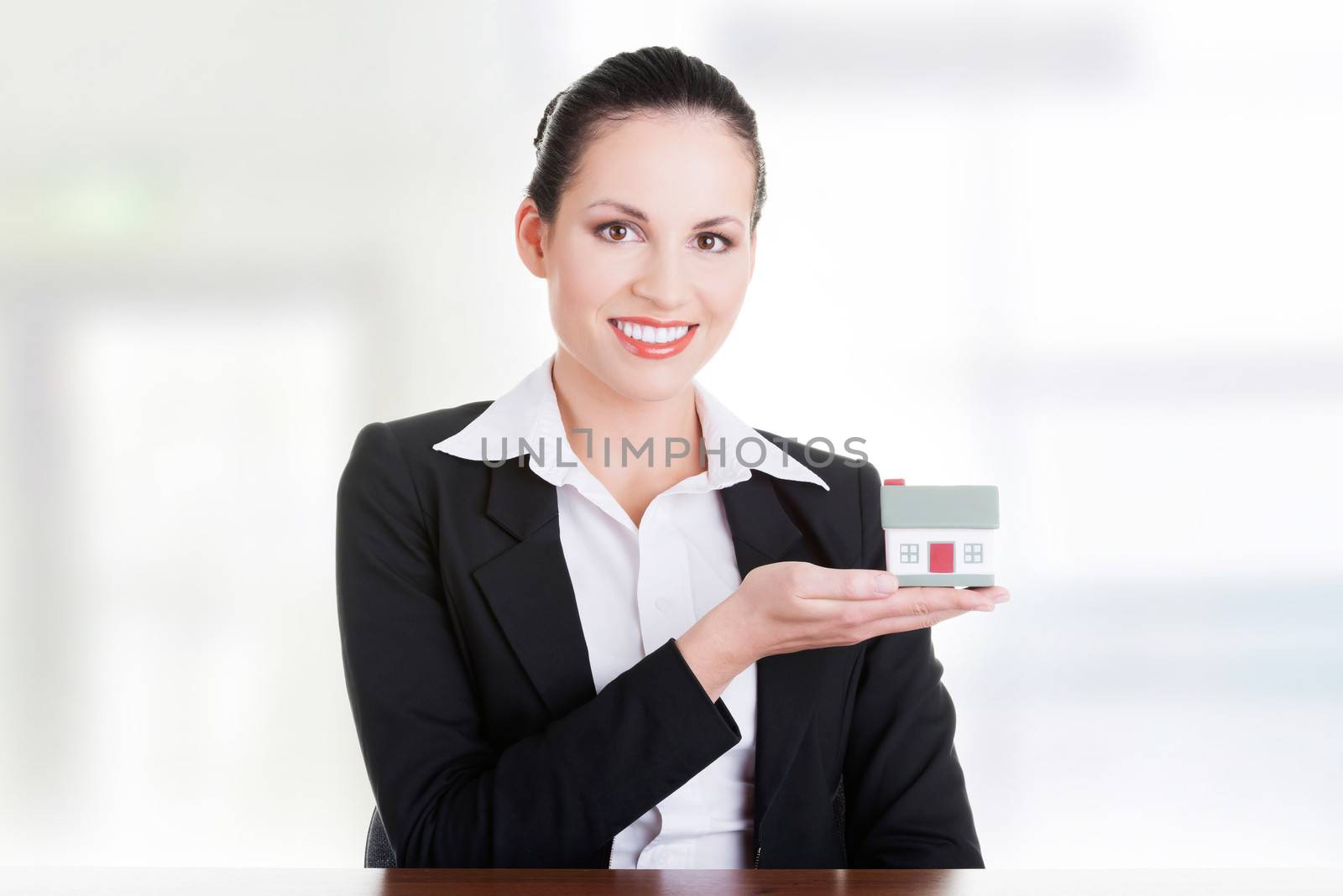 Businesswoman with house model over white - real estate loan or insurance concept