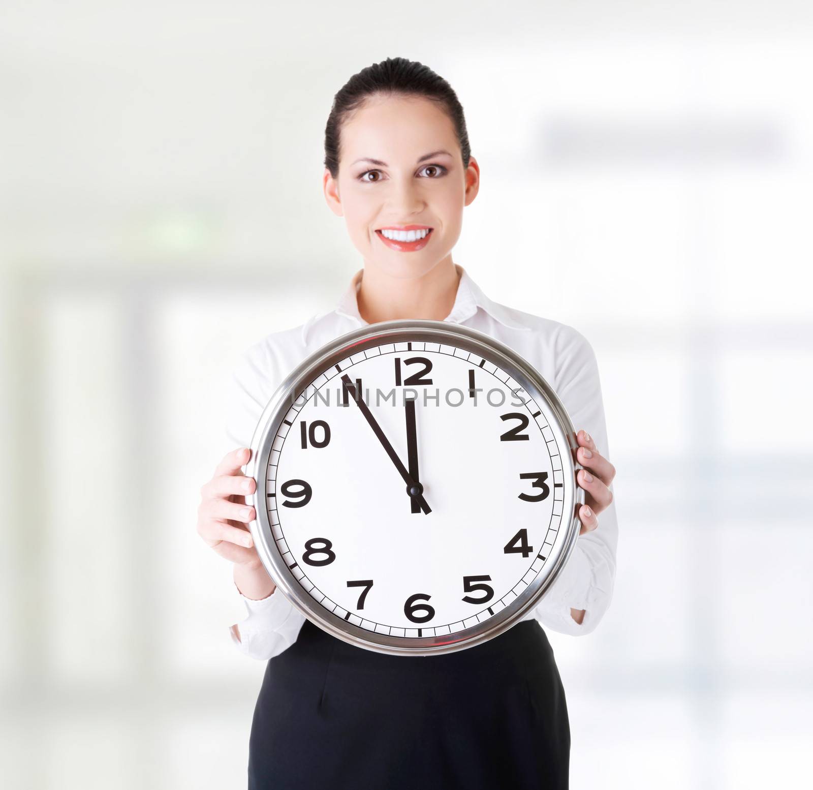 Happy young business woman holding office clock by BDS