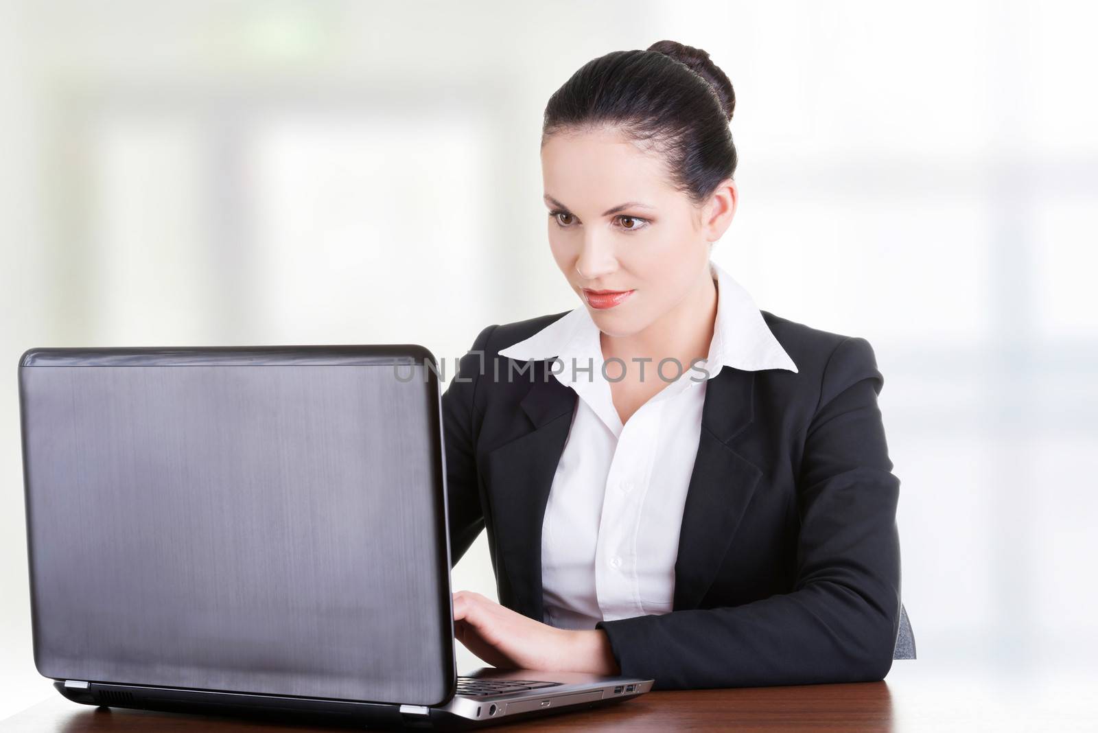 Beautiful brunette businesswoman working on laptop computer isolated on white