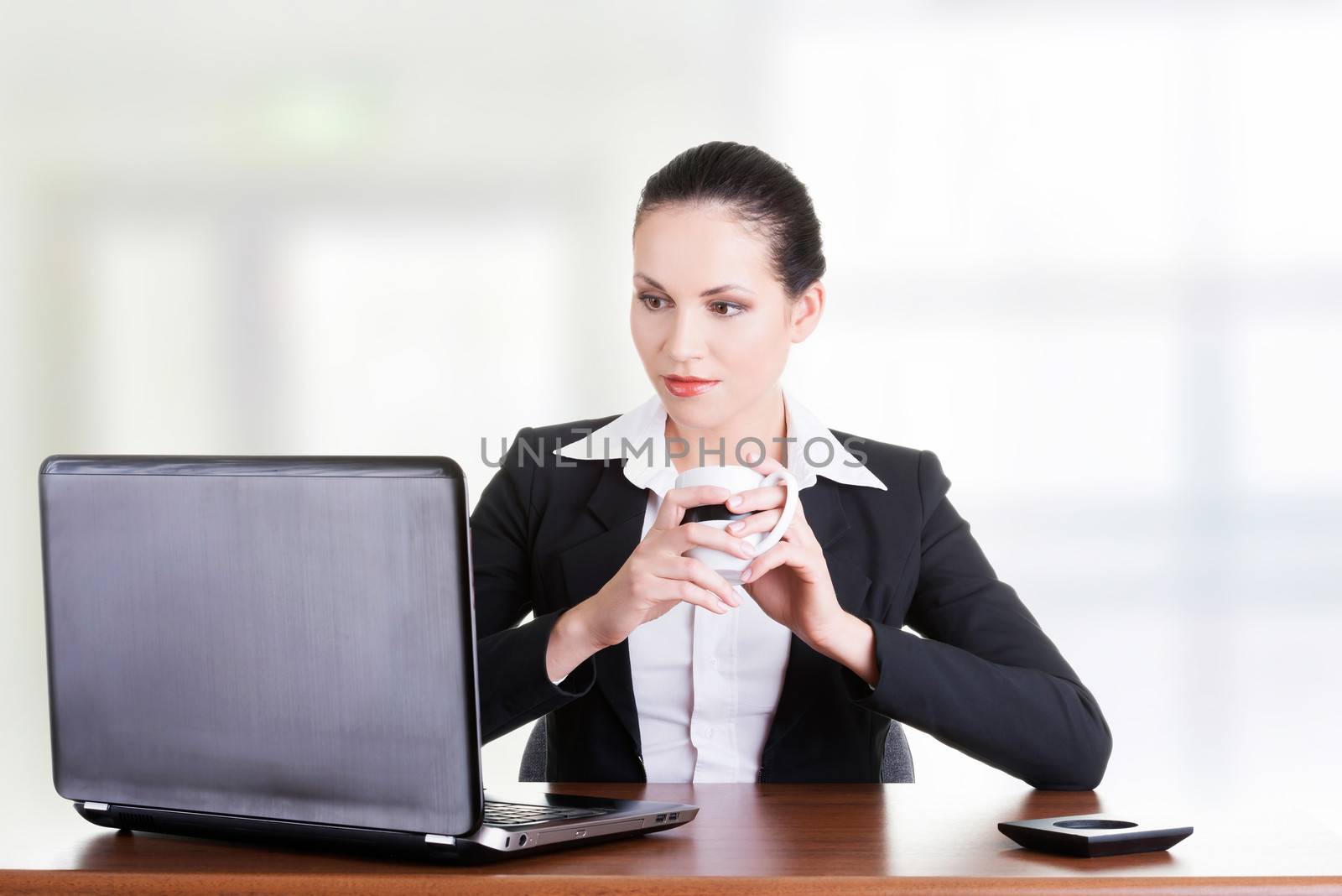 Beautiful brunette businesswoman working on laptop computer isolated on white