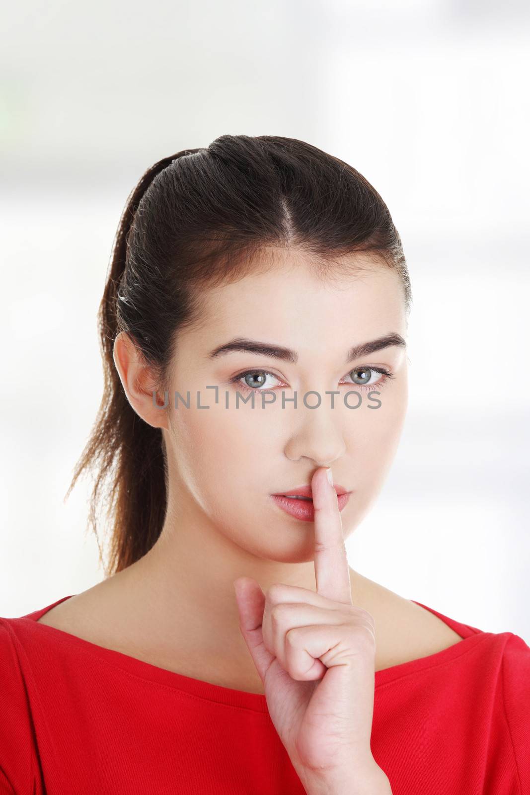 Attractive woman making a keep it quiet gesture , isolated on white