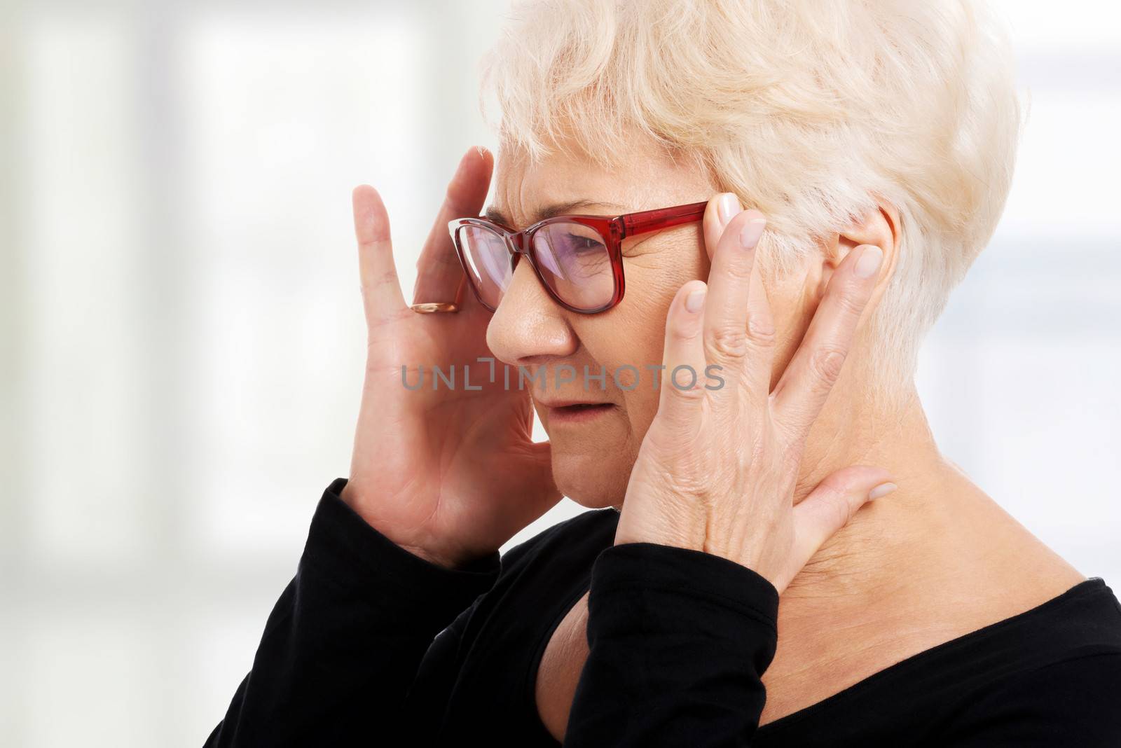 An old woman is eye glasses is having a headache. Isolated on white.