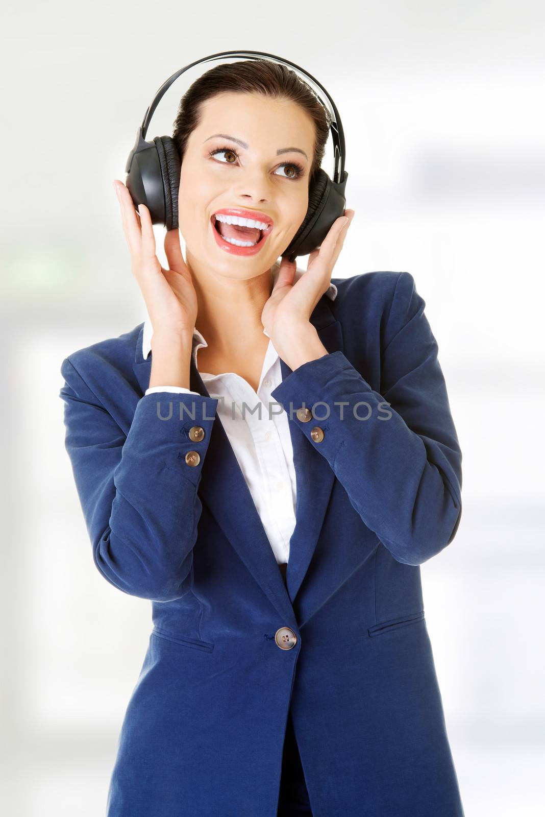 Young beautiful woman is listening to music with headphones.