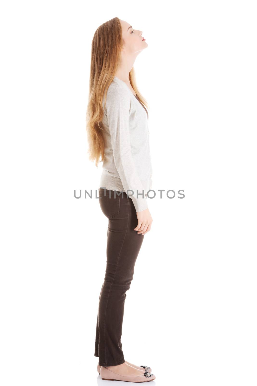 Beautiful casual woman is looking up. Side view. Isolated on white.