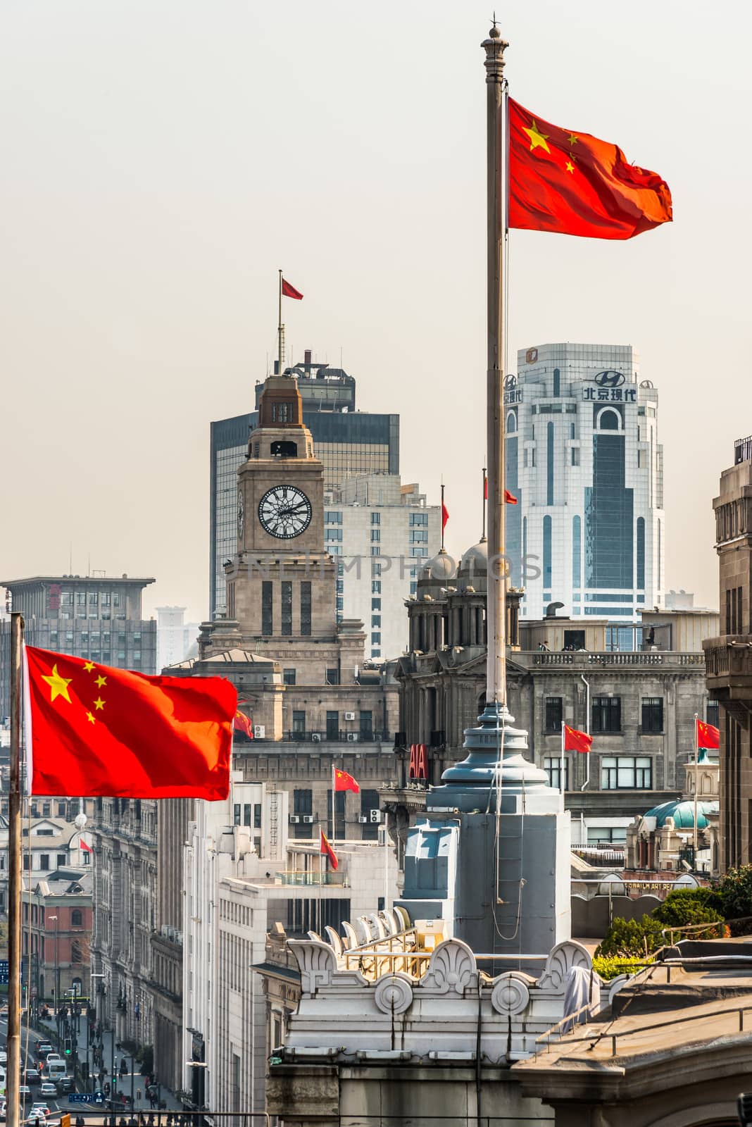 Shanghai, China - April 7, 2013: the bund rooftops and chineses flags at the city of Shanghai in China on april 7th, 2013