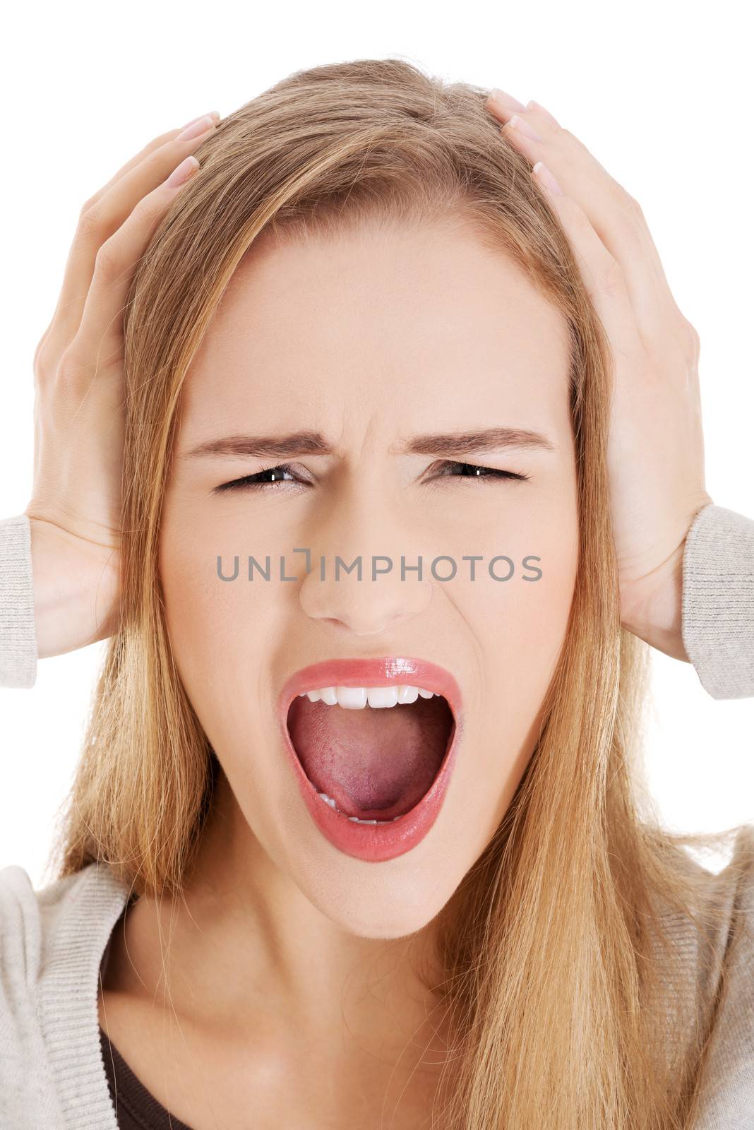 Beautiful casual woman screams and covers her ears. Isolated on white.