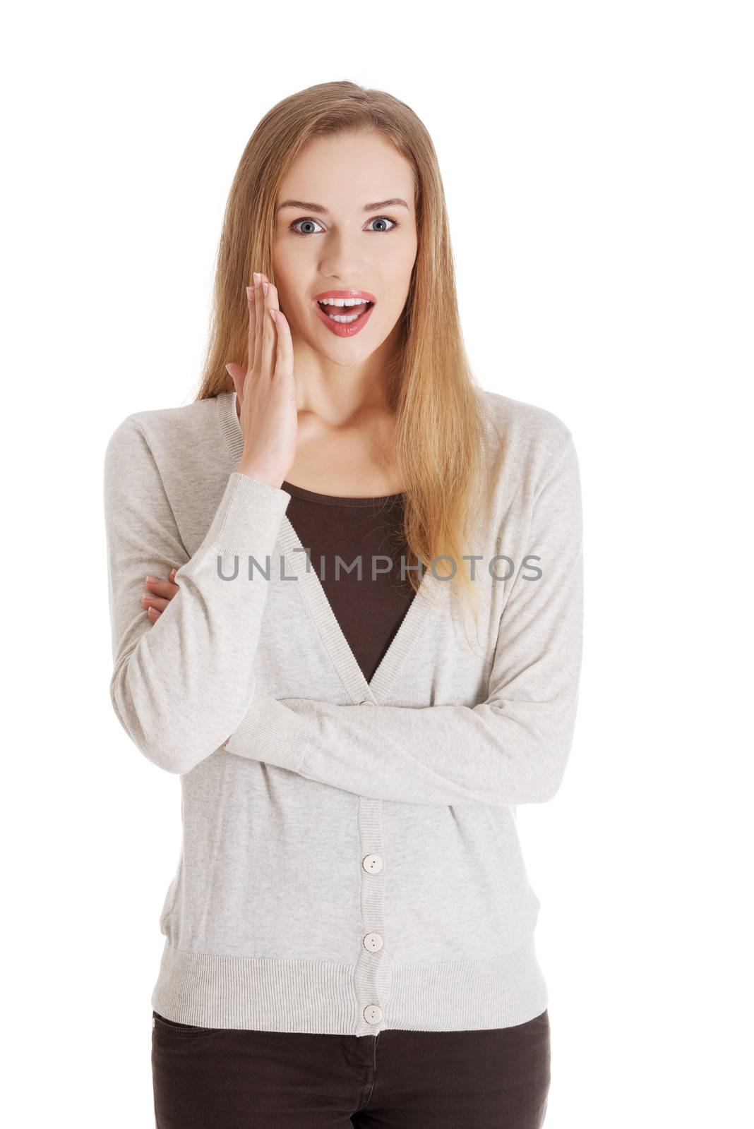 Beautiful positive and casual woman expressing surprise and advertising. Isolated on white.