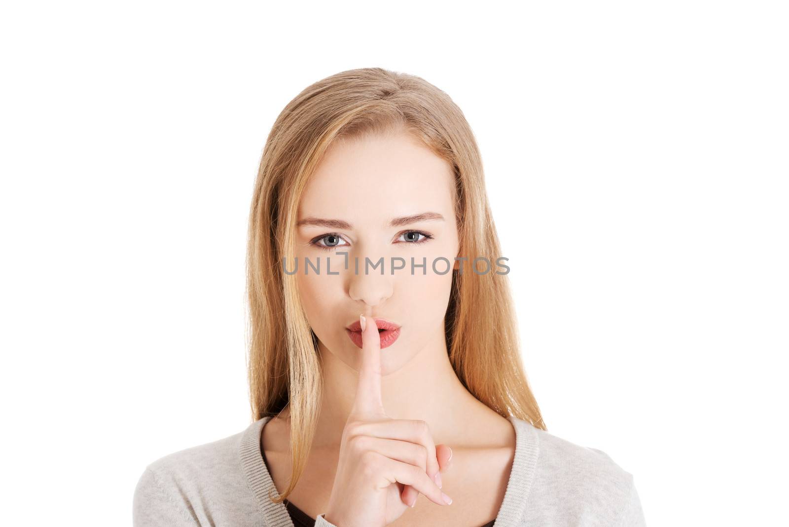 Beautiful woman with finger on lips. Isolated on white.