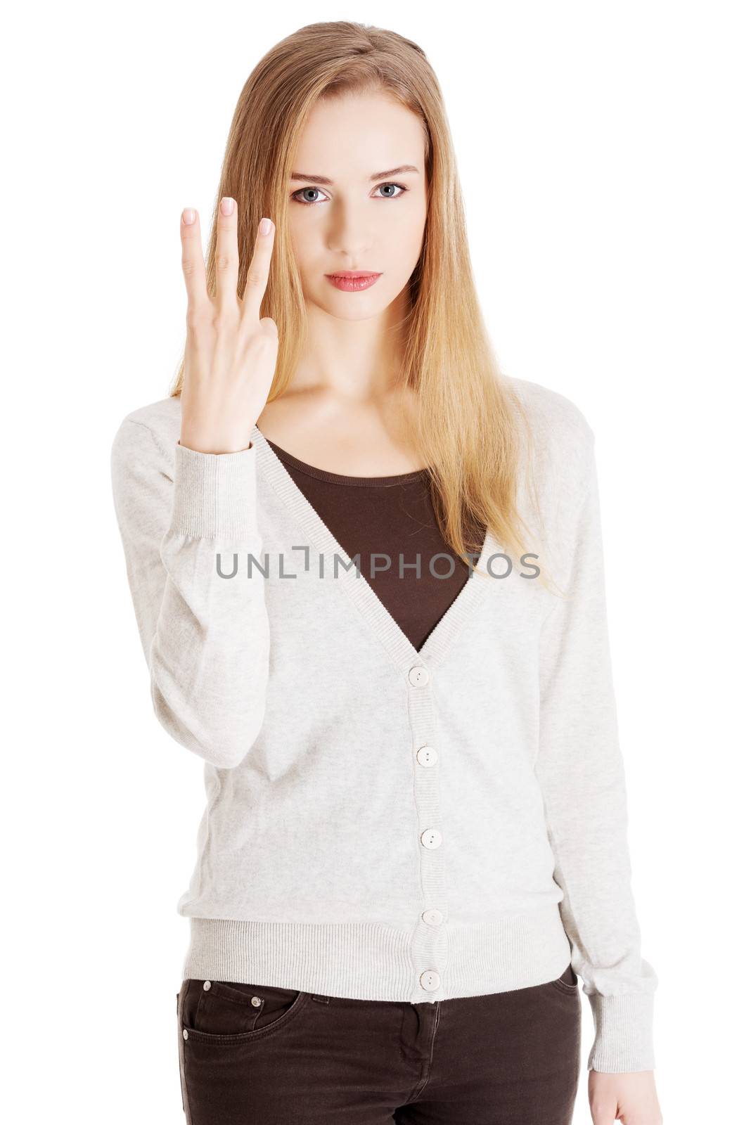 Beautiful casual woman showing three fingers. Isolated on white.