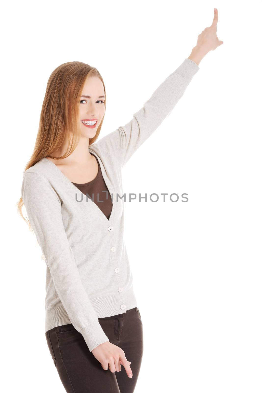 Beautiful casual woman pointing up and advertising. Isolated on white.