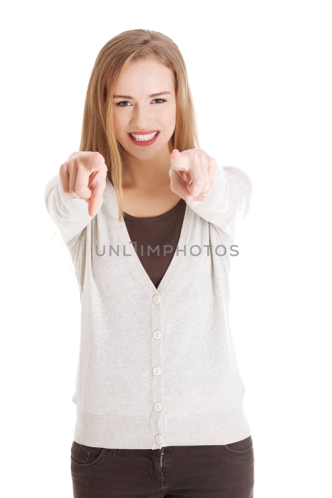 Beautiful casual woman pointing on you, advertising. Isolated on white.