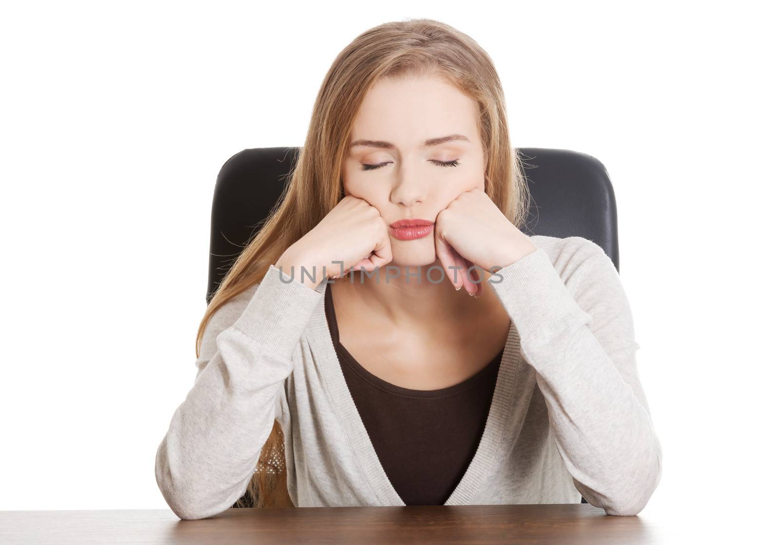 Beautiful casual, bored or sleeping student woman by a desk. Isolated on white.
