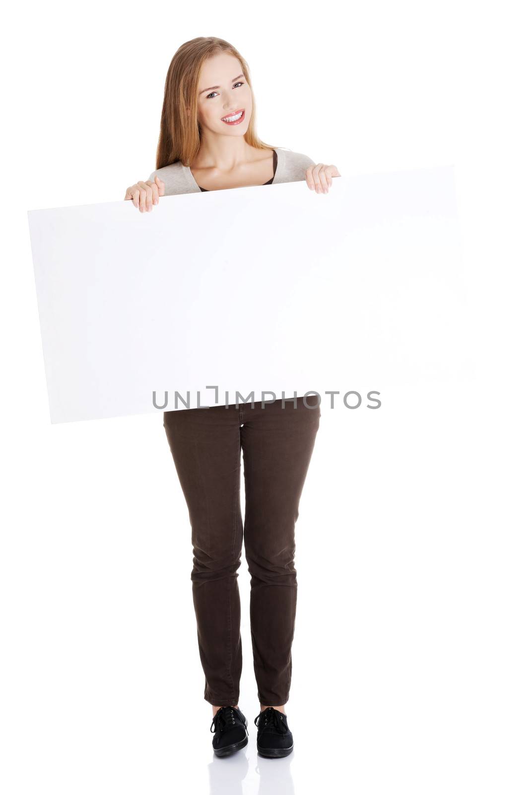 Beautiful casual woman holding copy space and advertising. Isolated on white.