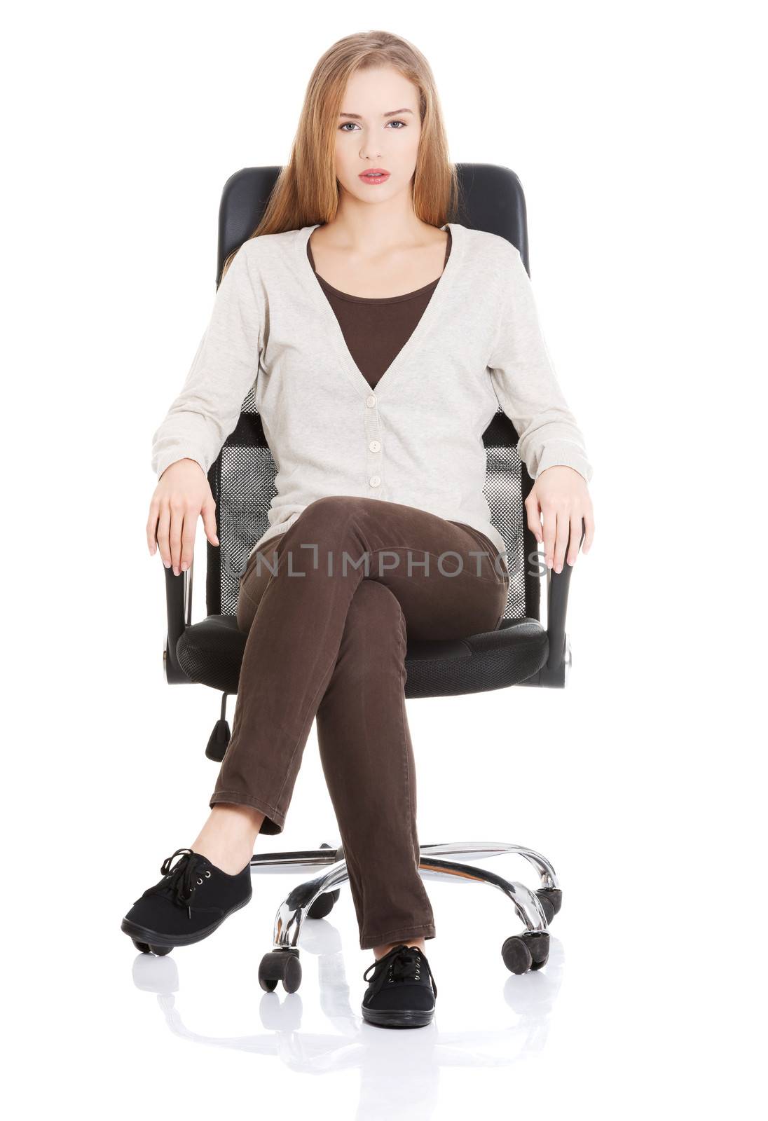 Beautiful casual woman sitting on a chair. Isolated on white.