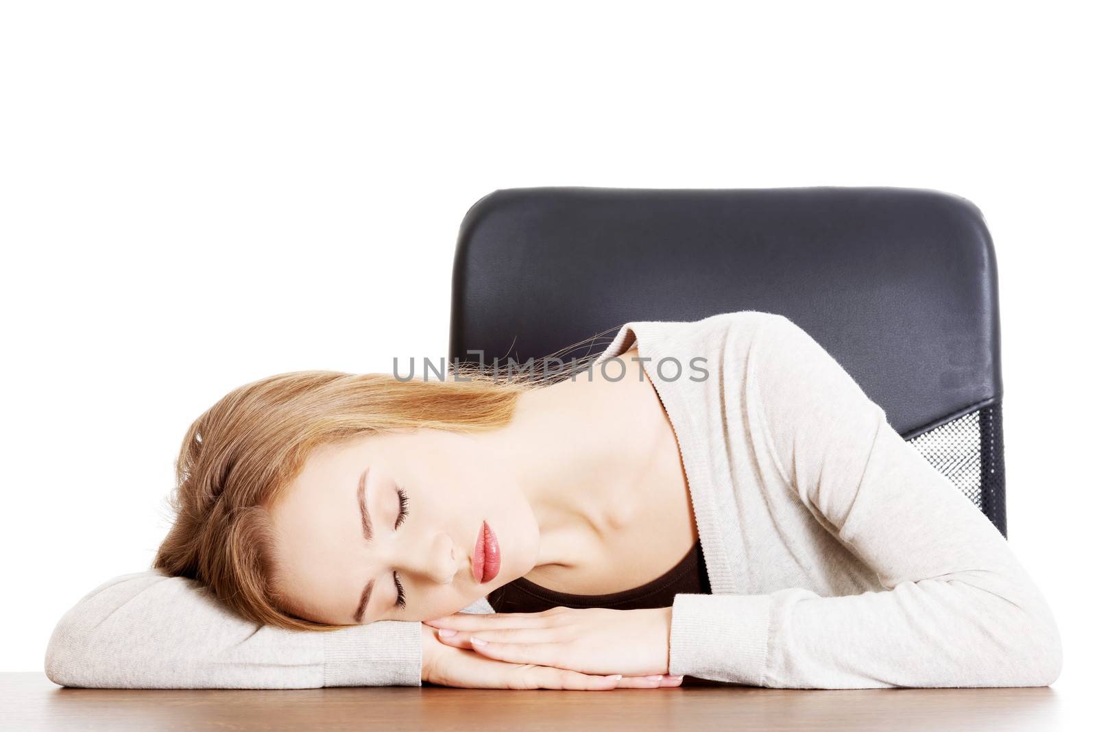 Young casual woman student is sleeping on a desk. Isolated on white.